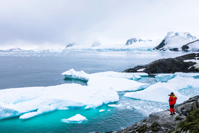 antarctica-traveler-taking-photo-glacier-icebergs-snow-mountains