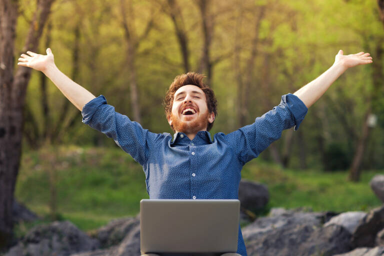 general-man-in-forest-laptop-cheering