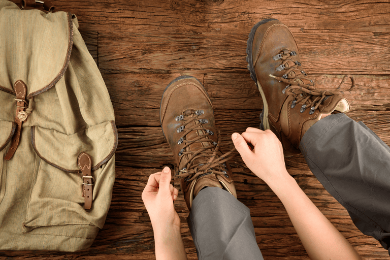 general-traveler-preparing-hike-boots-backpack