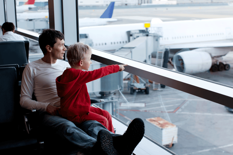 generic-father-son-looking-out-window-waiting-airport-airplanes