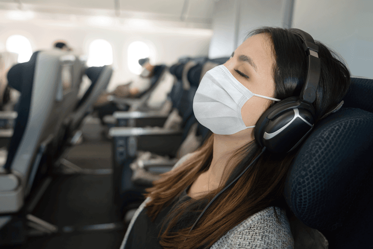 generic-passenger-woman-traveling-sleeping-onboard-airplane-mask