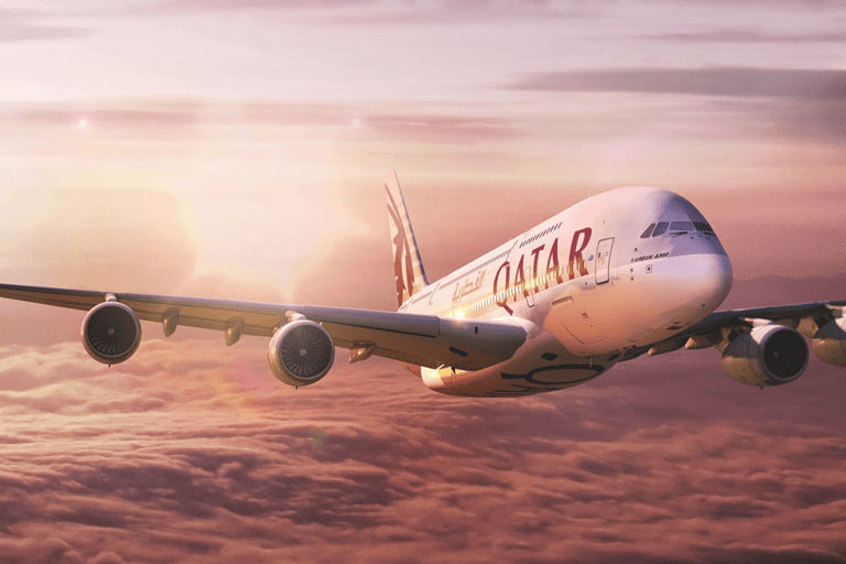 Qatar Airways plane above the clouds at sunset