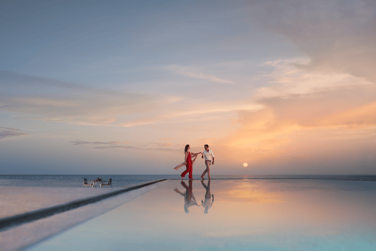 tb-abu-dhabi-zaya-nurai-island-couple-walking-infinity-pool-sunset